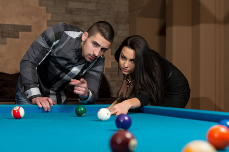 Young Caucasian Woman Receiving Advice On Shooting Pool Ball While Playing Billiardsの写真素材