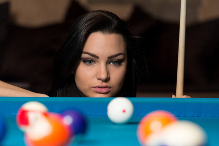 Young Woman Playing Billiards Lined Up To Shoot Easy Winning Shot