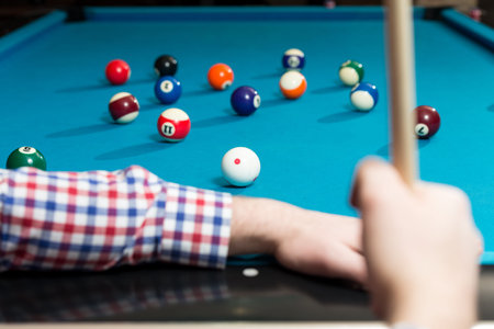 Young Man Playing Billiards Lined Up To Shoot Easy Winning Shot