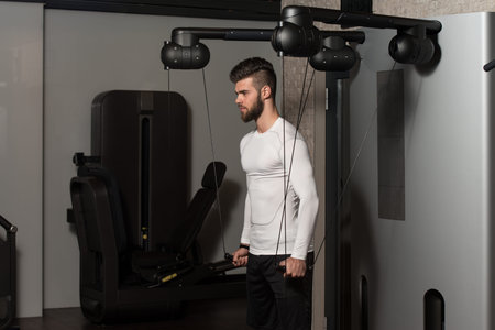 Handsome Man Is Working On His Shoulders With Cable Crossover In A Modern Gym