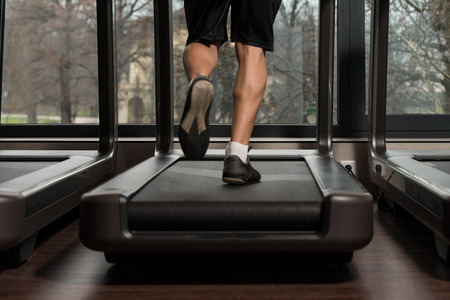 Close Up Of Male Legs Running On Treadmill - Blurred Motionの写真素材