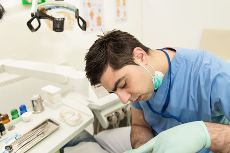 Male Patient With Dentist And Assistant In A Dental Treatment - Wearing Masks And Glovesの写真素材