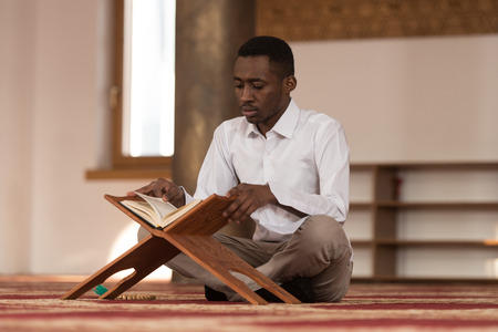 Black African Muslim Man Is Reading The Koranの写真素材