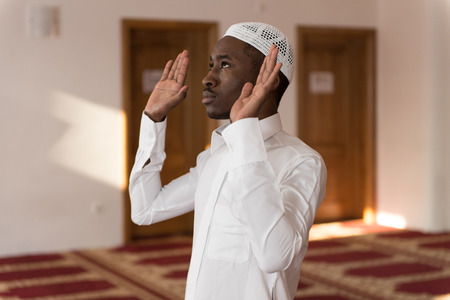 African Muslim Man Making Traditional Prayer To God While Wearing A Traditional Cap Dishdashaの写真素材