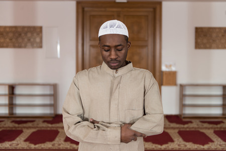 African Muslim Man Making Traditional Prayer To God While Wearing A Traditional Cap Dishdashaの写真素材