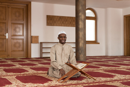 Black African Muslim Man Reading Holy Islamic Book Koranの写真素材