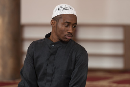 African Muslim Man Making Traditional Prayer To God While Wearing A Traditional Cap Dishdashaの写真素材