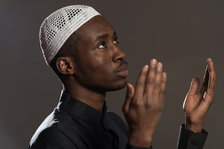 African Muslim Man Making Traditional Prayer To God While Wearing A Traditional Cap Dishdashaの写真素材