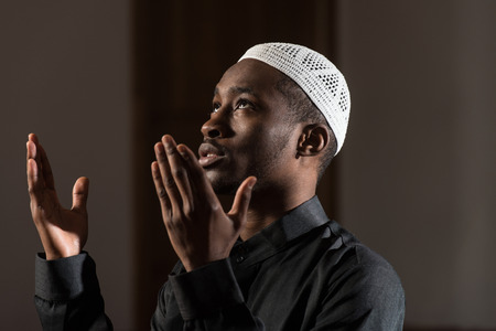 African Muslim Man Making Traditional Prayer To God While Wearing A Traditional Cap Dishdashaの写真素材