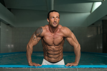 Happy Attractive Muscular Mature Man Resting Relaxed On Edge Of Swimming Pool