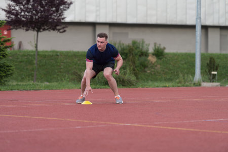 Young Man Running To The Cone On Sports Field
