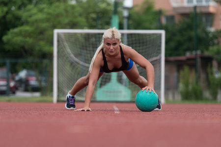Young Woman Outdoors Performing Push Ups On Medicine Ball Bodybuilding Exercise