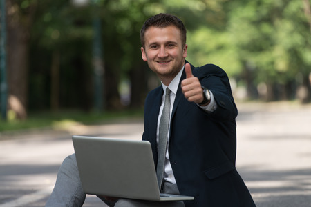 Happy Business Man Using Tablet Pc Outside On Asphaltの写真素材