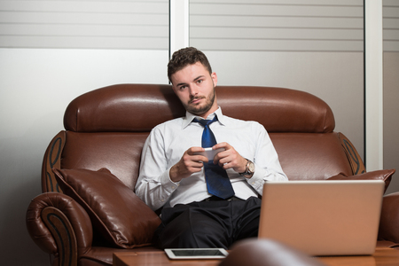 Young Businessman Working In His Office While Talking On The Phoneの写真素材