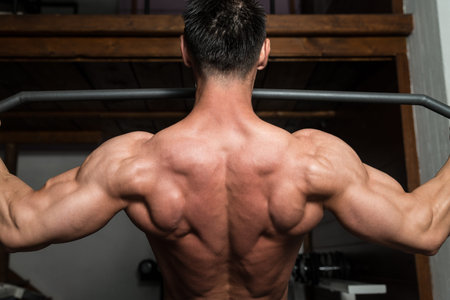 Bodybuilder Doing Heavy Weight Exercise For Back