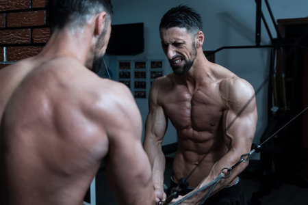 Bodybuilder Is Working On His Chest With Cable Crossover In A Dark Gym