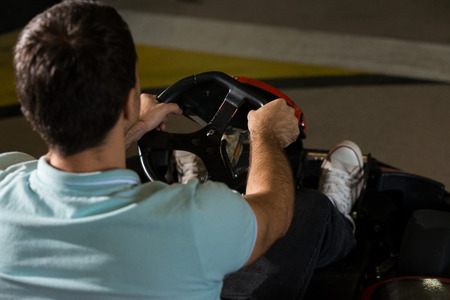 Young Man Is Driving Go-Kart Car With Speed In A Playground Racing Track - Go Kart Is A Popular Leisure Motor Sportsの写真素材