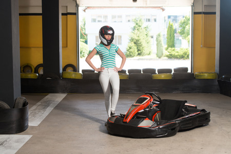 Young Woman Is Driving Go-Kart Car With Speed In A Playground Racing Track - Go Kart Is A Popular Leisure Motor Sportsの写真素材
