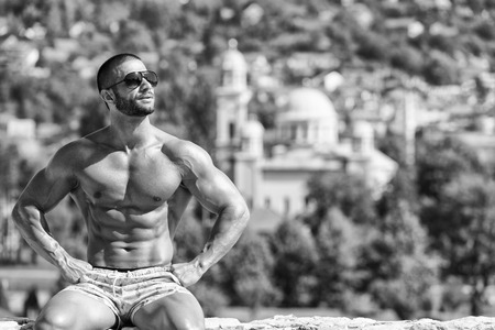 Portrait Of A Physically Fit Man Showing His Well Trained Body Outdoors In Summer Timeの写真素材