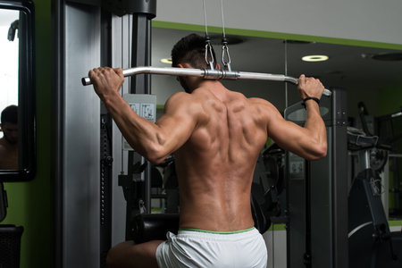 Arabic Bodybuilder Doing Heavy Weight Exercise For Back On Machine