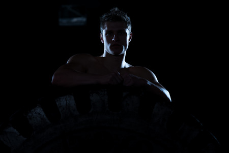 Siluet Portrait Of Muscular Young Man With Tireの写真素材