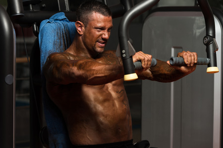 Adult Bodybuilder Doing Heavy Weight Exercise For Chest On Machineの写真素材