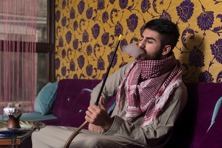 Muslim Man Smoking Shisha At Arabic Restaurant - Exhaling Smokeの写真素材