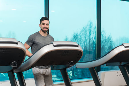 Handsome Man Running On The Treadmill In Gym