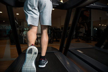 Close Up Of Male Legs Running On Treadmill - Blurred Motionの写真素材