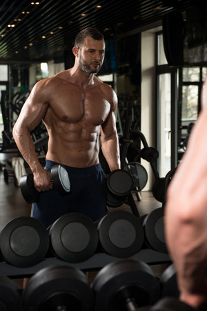 Portrait Of A Physically Fit Man Showing His Well Trained Body In Gymの写真素材