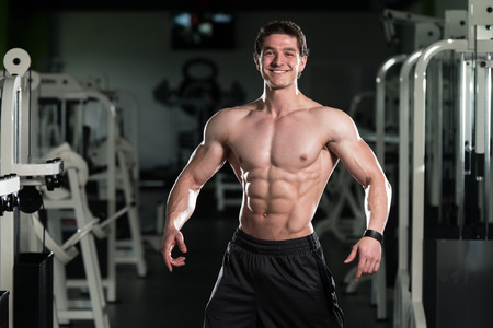 Bodybuilder Posing In Different Poses Demonstrating Their Muscles - Male Showing Muscles Straining - Beautiful Muscular Body Athleteの写真素材