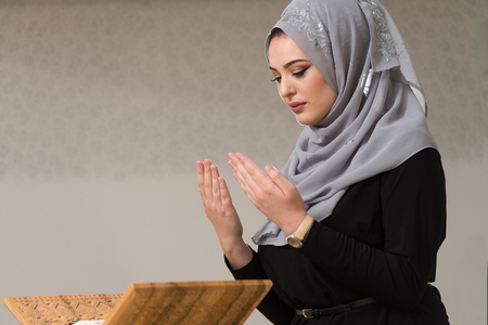 Muslim Woman Reading Koran Or Quran Wearing Traditional Dress At The Mosqueの写真素材