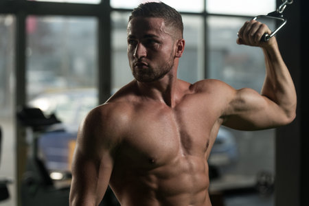 Young Bodybuilder Doing Heavy Weight Exercise For Biceps On Machine