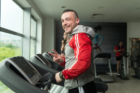 Handsome Man Running On The Treadmill In Gym