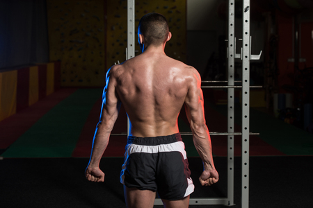 Portrait Of A Young Fit Man Showing Side Triceps Pose - Muscular Athletic Bodybuilder Fitness Model Posing After Exercisesの写真素材