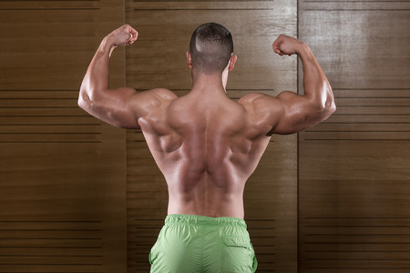 Bodybuilder Posing In Different Poses Demonstrating Their Muscles - Male Showing Muscles Straining - Beautiful Muscular Body Athleteの写真素材