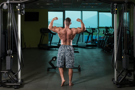 Bodybuilder Posing In Different Poses Demonstrating Their Muscles - Male Showing Muscles Straining -...
