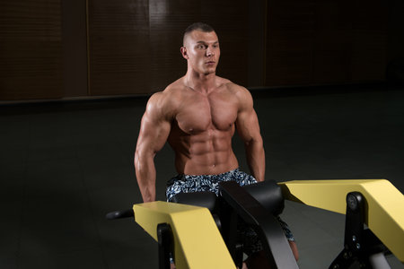 Young Bodybuilder Doing Heavy Weight Exercise For Trapezius