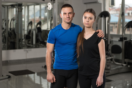 Portrait Of Fit Couple Together Standing In A Gym Looking Positiveの写真素材