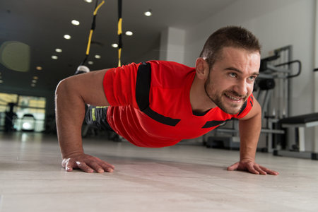Personal Trainer Does Crossfit With Trx Fitness Straps In The Gym's Studio