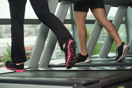 Close Up Of Couples Legs Running On Treadmill - Blurred Motionの写真素材