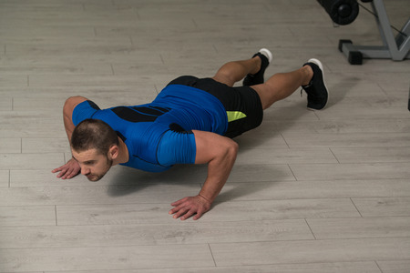Personal Trainer Doing Pushups On Floor In Gym As Part Of Bodybuilding Trainingの写真素材