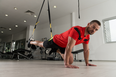 Personal Trainer Does Crossfit With Trx Fitness Straps In The Gym's Studioの写真素材