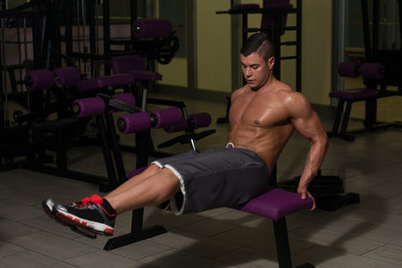 Young Healthy Man Exercising Abdominals On Bench