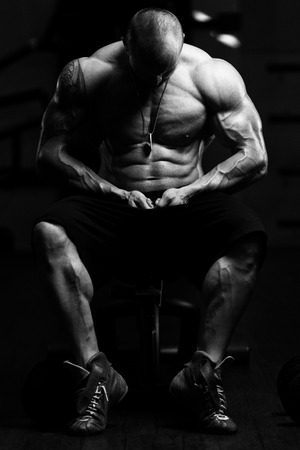 Man Standing Strong In The Gym And Flexing Muscles - Muscular Athletic Bodybuilder Fitness Model Posing After Exercisesの写真素材