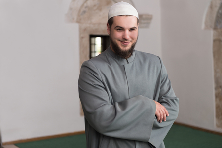 Young Muslim Man Making Traditional Prayer To God While Wearing A Traditional Cap Dishdashaの写真素材