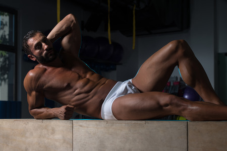 Portrait Of A Sexy Muscular Man In Underwear Resting On Box After Exerciseの写真素材