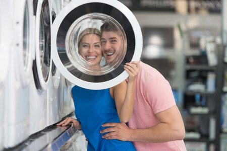 Beautiful Young Couple Shopping For Washing Machine In Produce Department Of A Grocery Store - Supermarket - Shallow Deep Of Fieldの写真素材