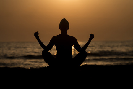 Young Healthy Woman Practicing Yoga Fitness Exercise on the Beach at Sunset - Healthy Lifestyle Concept - Copy Space Textの写真素材