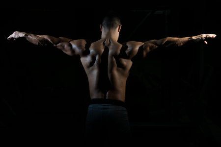Healthy Man Standing Strong In The Gym And Flexing Muscles - Muscular Athletic Bodybuilder Fitness...